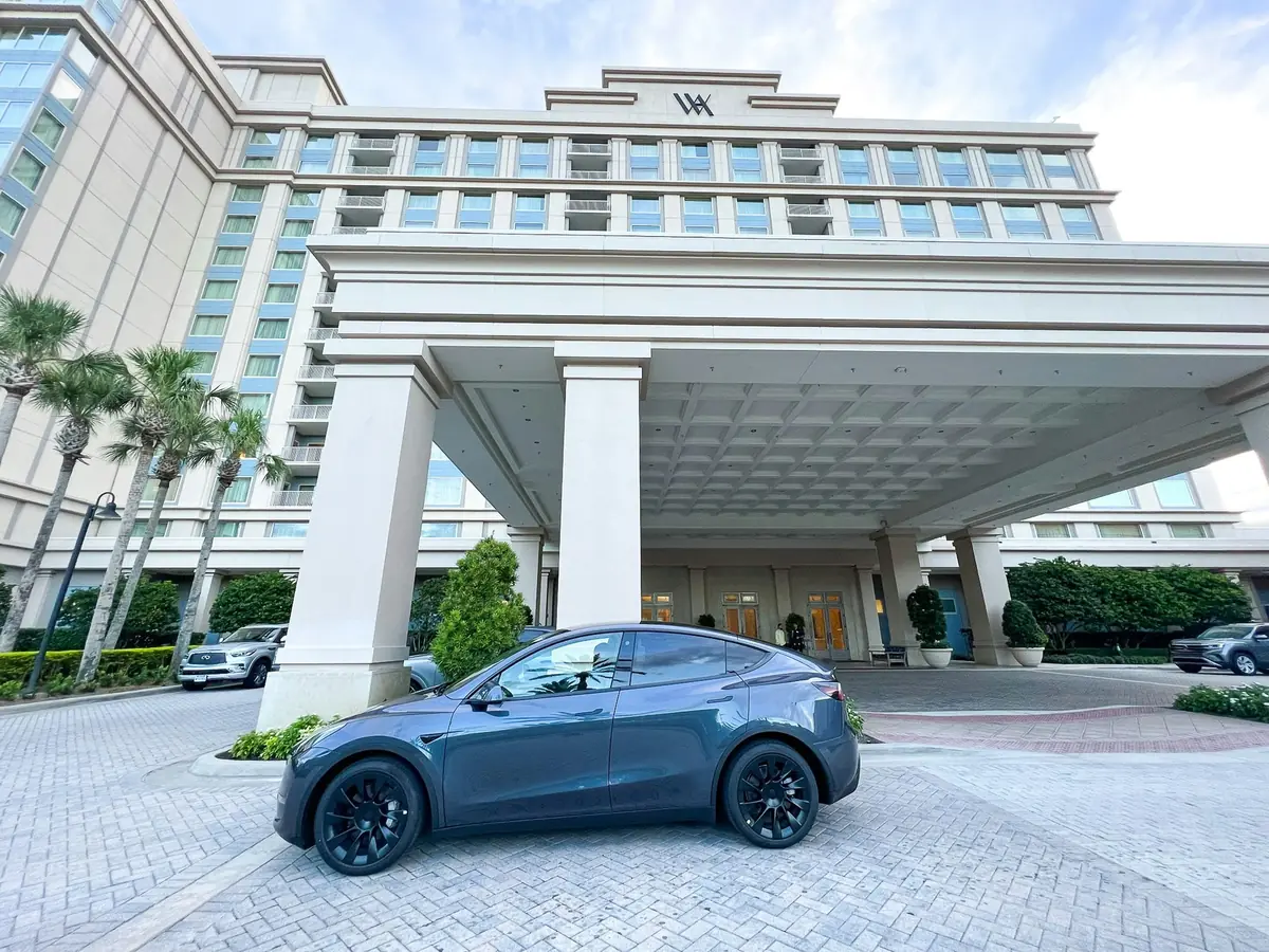 A car parked under a hotel's covered entrance