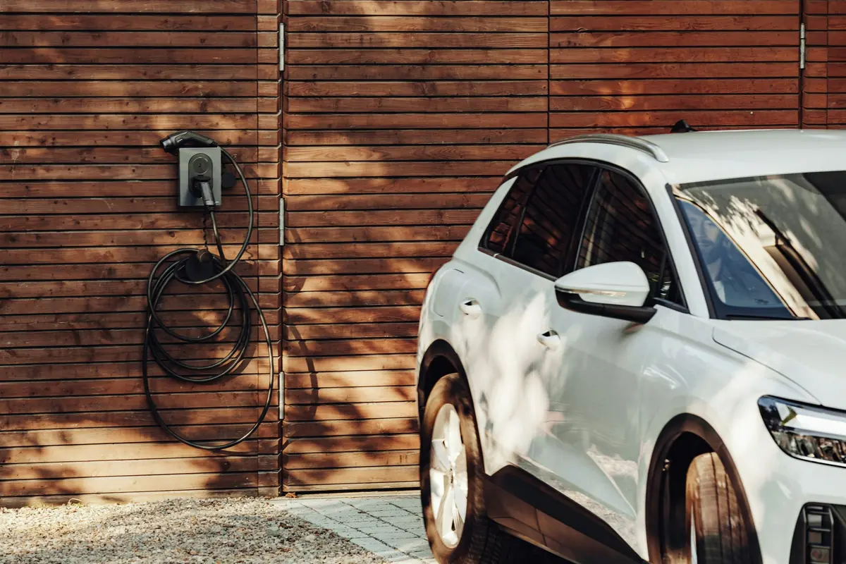 An SUV parked by a wall charger on a timber wall