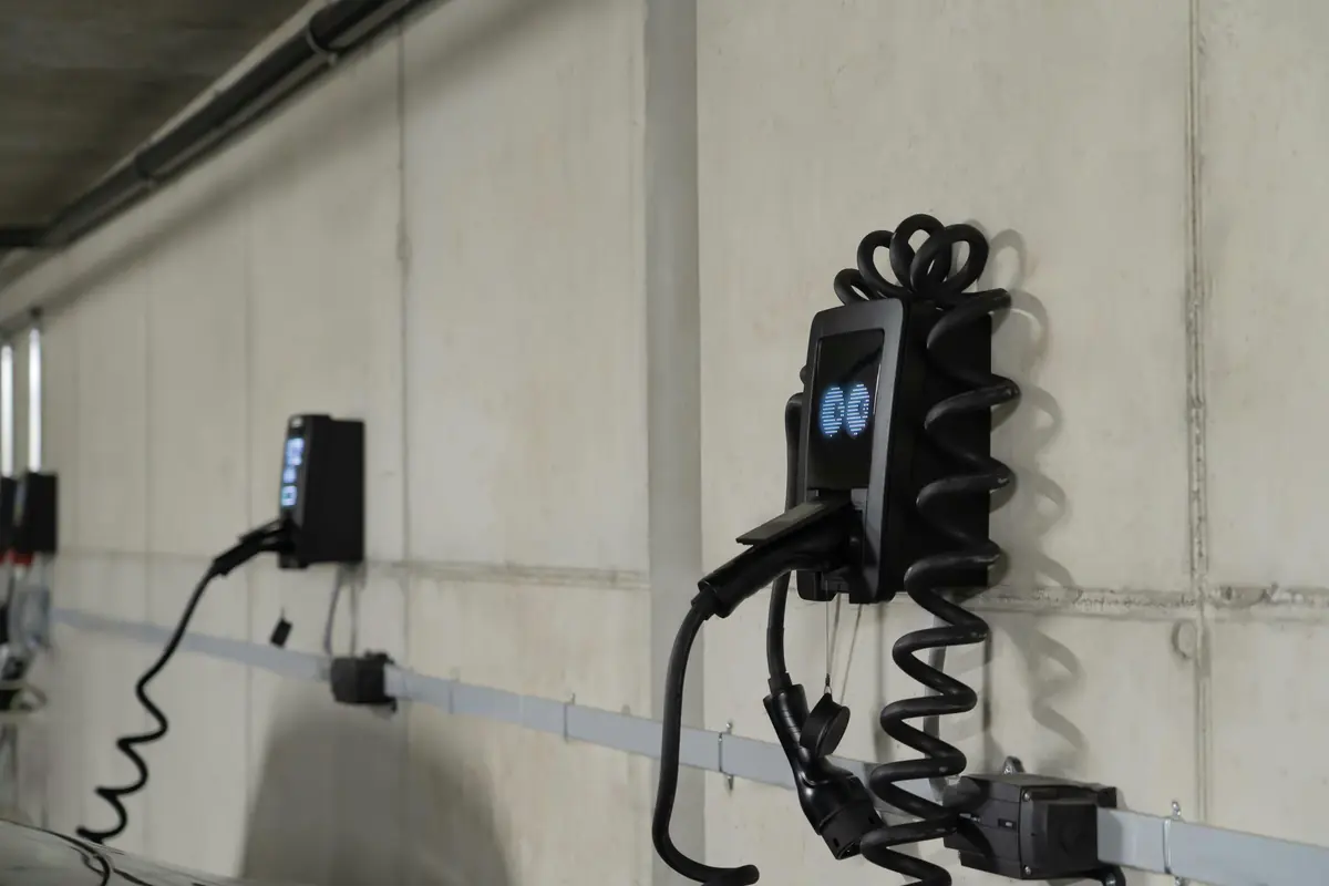 Two wall chargers mounted on a concrete garage wall