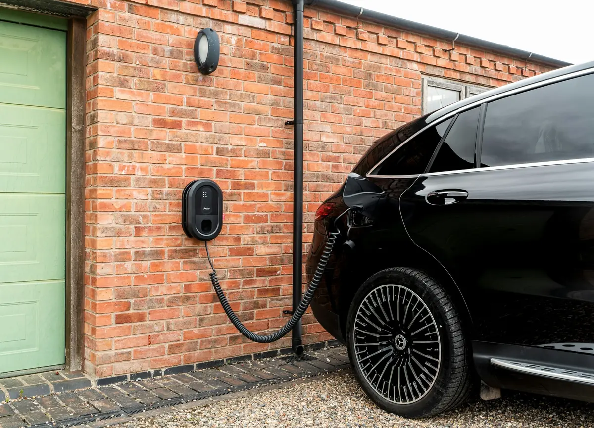 A car charging from a wall unit on a brick building