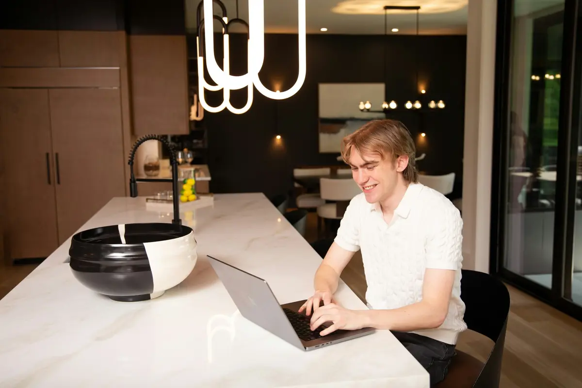 A man works on a laptop at a kitchen island