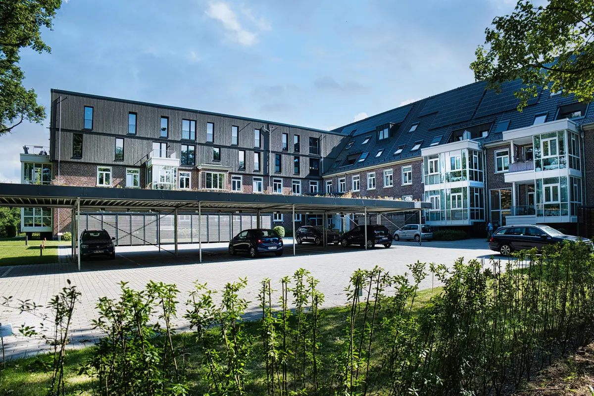 An apartment building with covered parking in front