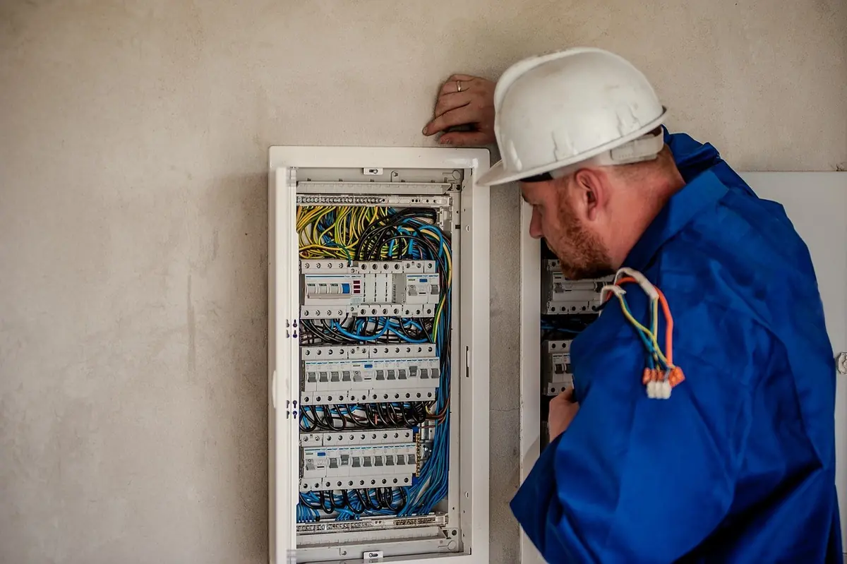 An electrician works in a breaker panel