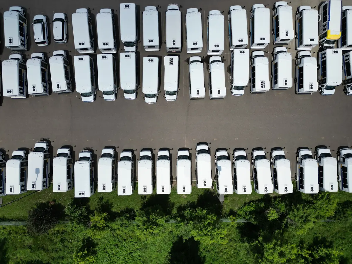 Rows of white vans in a depot, seen from above